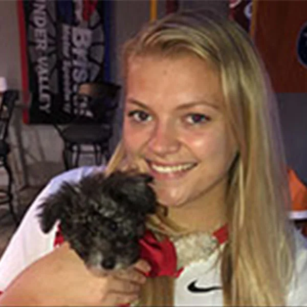 Halee holding a small dark gray dog